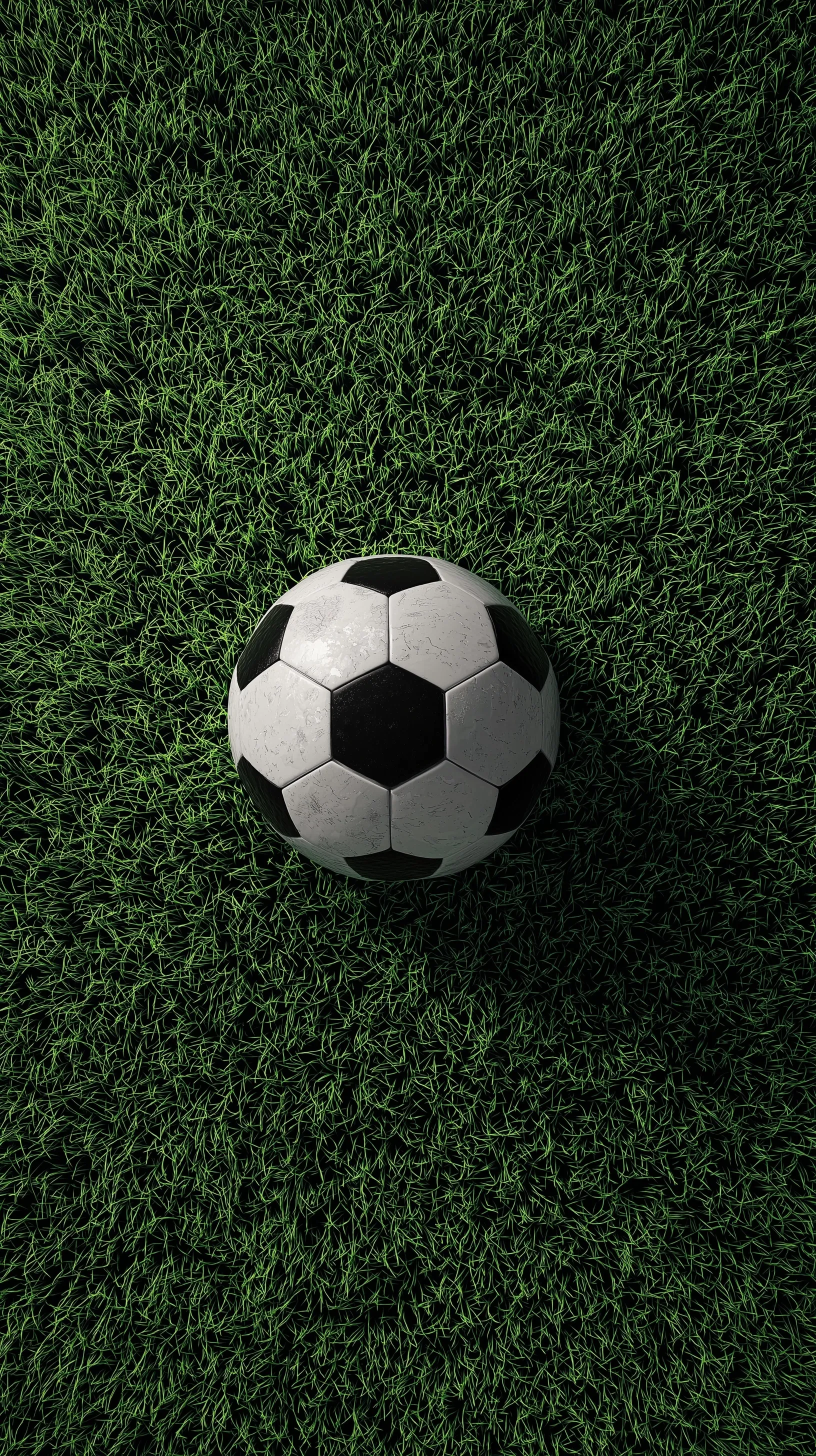A 3D realistic soccer ball resting on vibrant green grass against a dark background, top-down view.