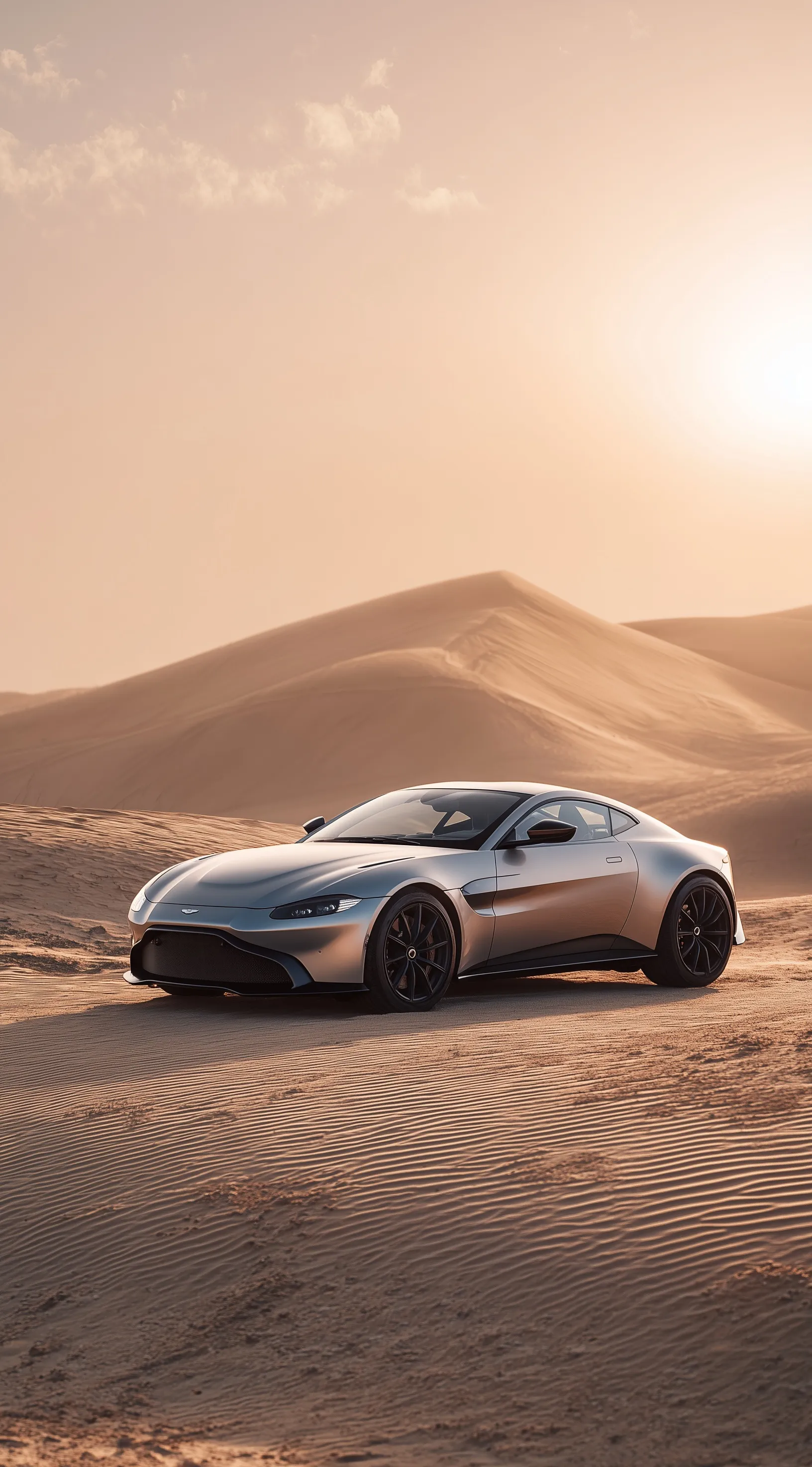 Silver Aston Martin Vantage sports car parked on desert sand dunes under cinematic lighting.