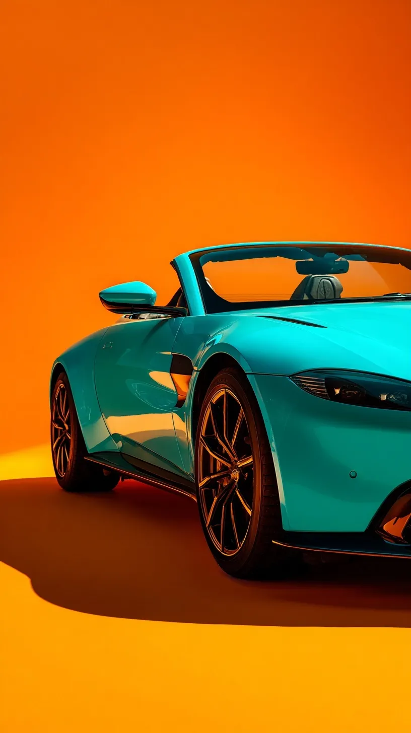 Turquoise Aston Martin Vantage Roadster on orange background in a minimalist cinematic studio setting.