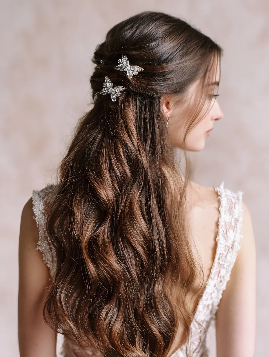 Back view of woman with long brown wavy hair in a half-up hairstyle featuring elegant sparkling crystal butterflies.