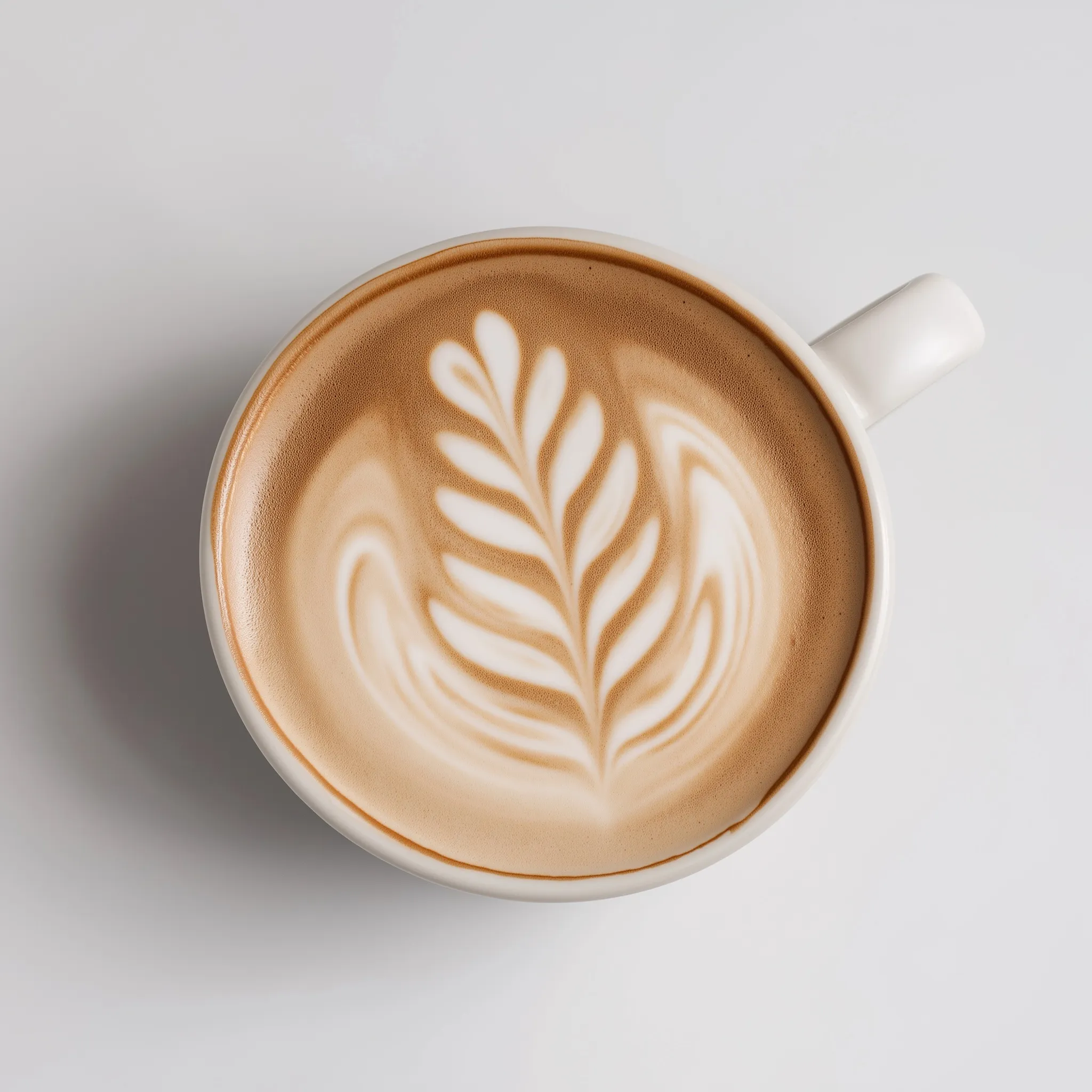 A minimalist cappuccino with elegant latte art centered on a clean white background.