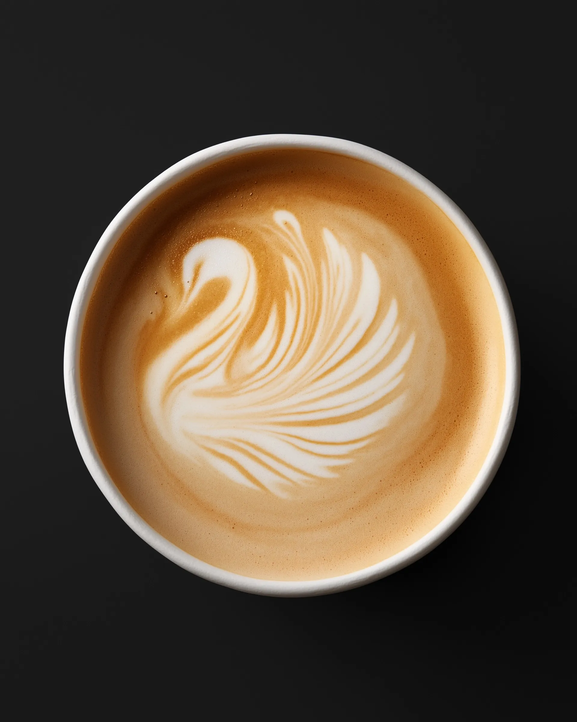 Top-down view of a takeaway coffee cup with swan latte art on a black background.