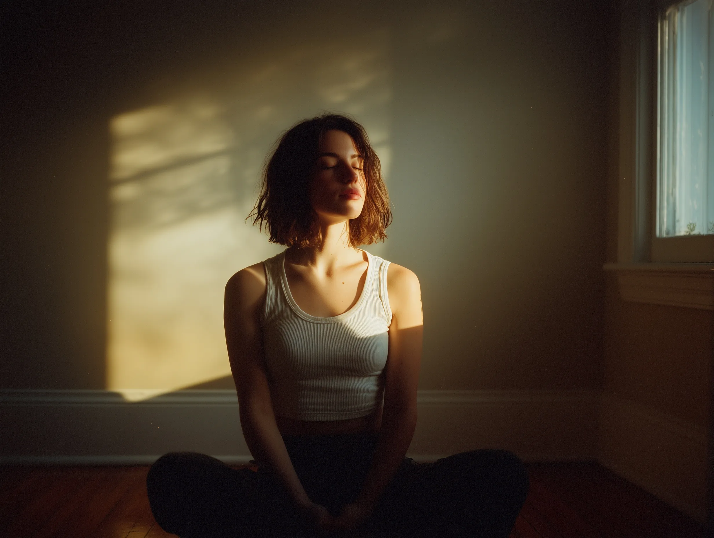 A peaceful woman practicing mindful meditation in a sunlit minimal room with warm neutral tones.