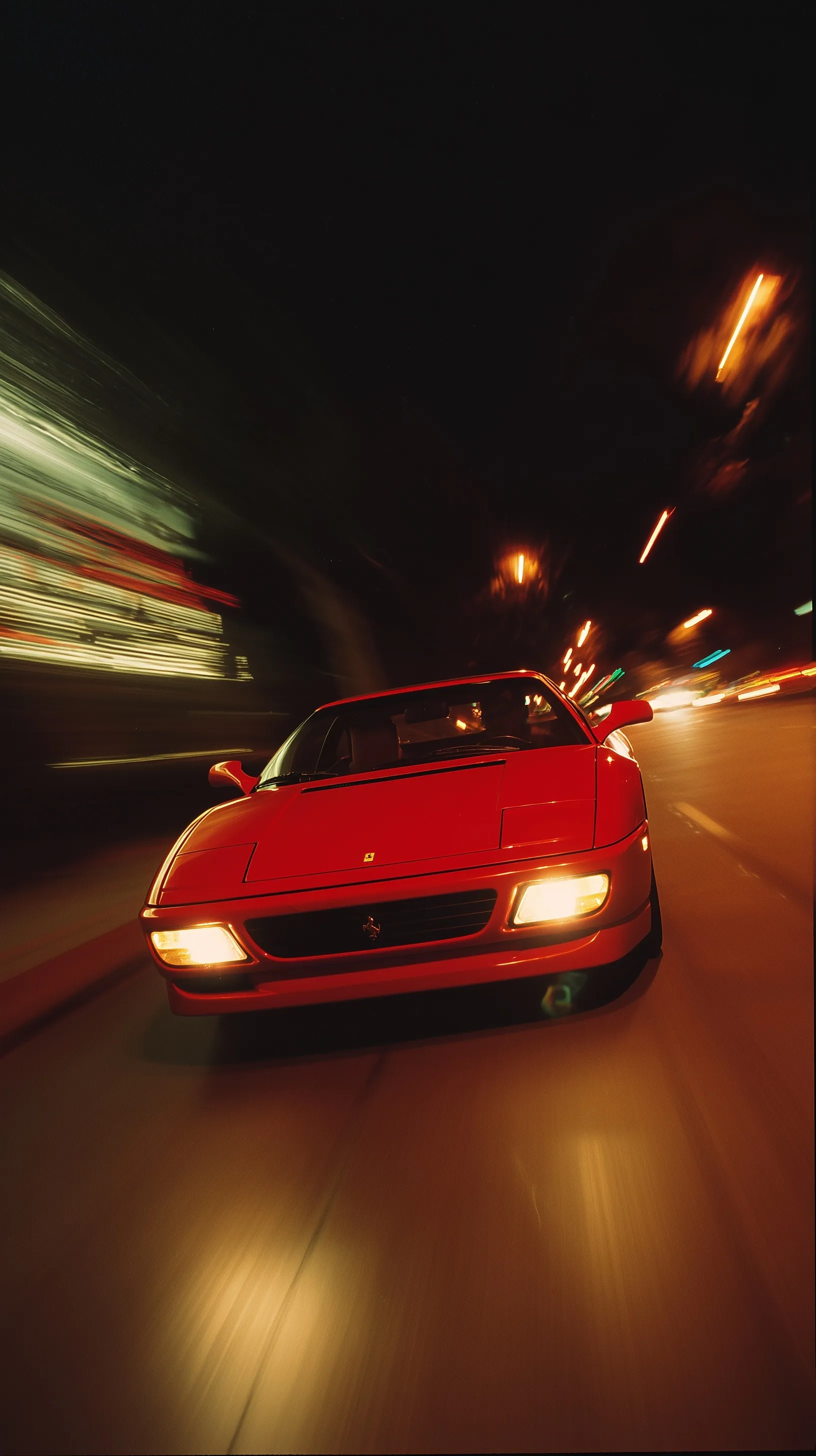 A sleek Ferrari 348 GTB captured in heavy motion blur on a California road at midnight with a vintage film aesthetic.