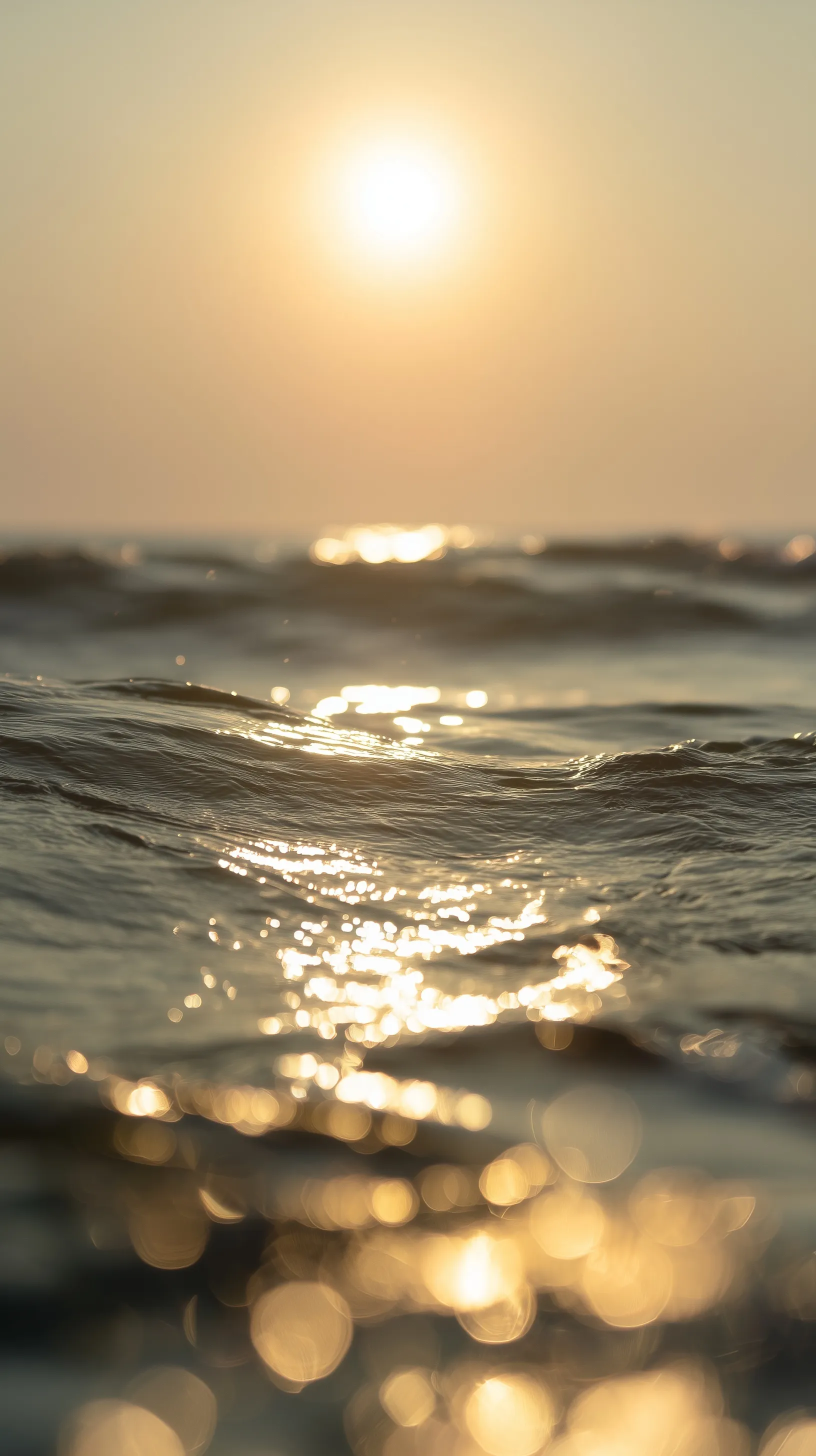 Sun shining on sparkling ocean waves during golden hour with a dreamy, soft-focus aesthetic.