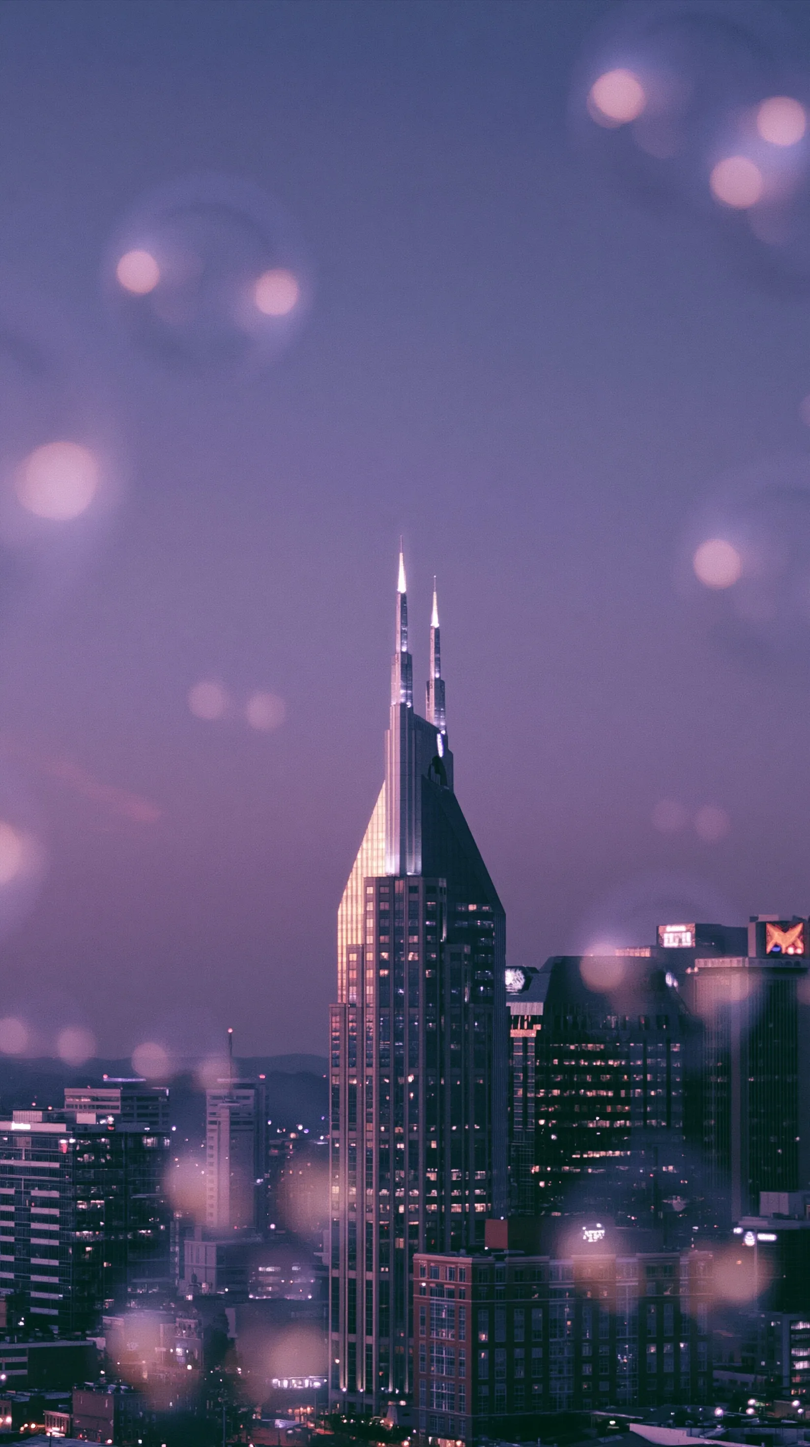 Nashville skyline at dusk with shimmering AT&T building silhouette and floating bubbles, dreamy aesthetic.
