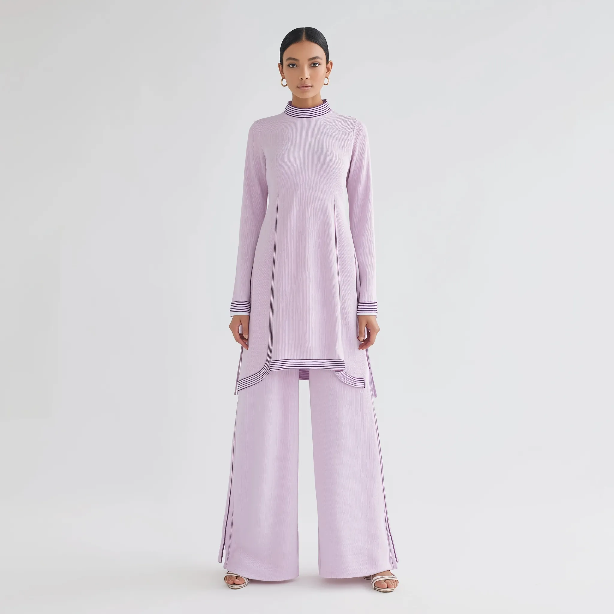 A model wearing a light purple modest modal co-ord set with a tunic, side cuts, piping, and matching palazzo trousers.