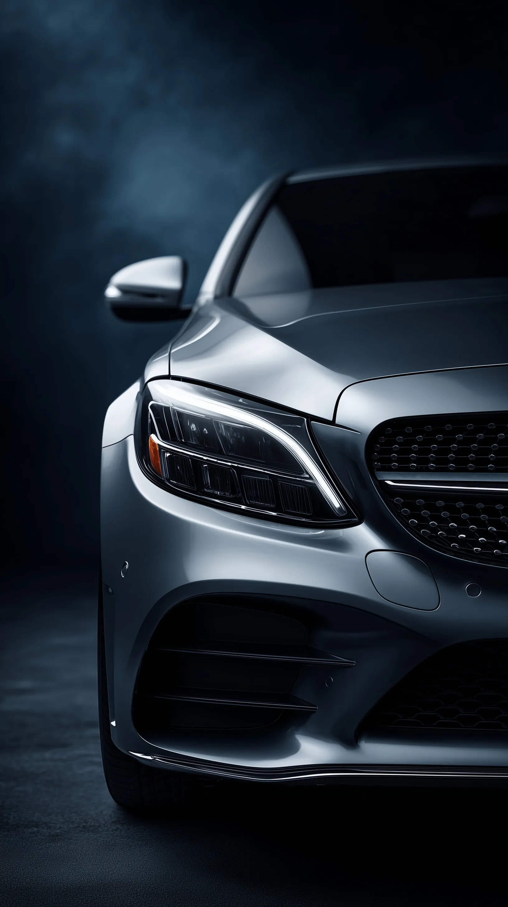 Close-up of a grey Mercedes C-Class luxury sports car in a cinematic dark studio with dramatic rim lighting.