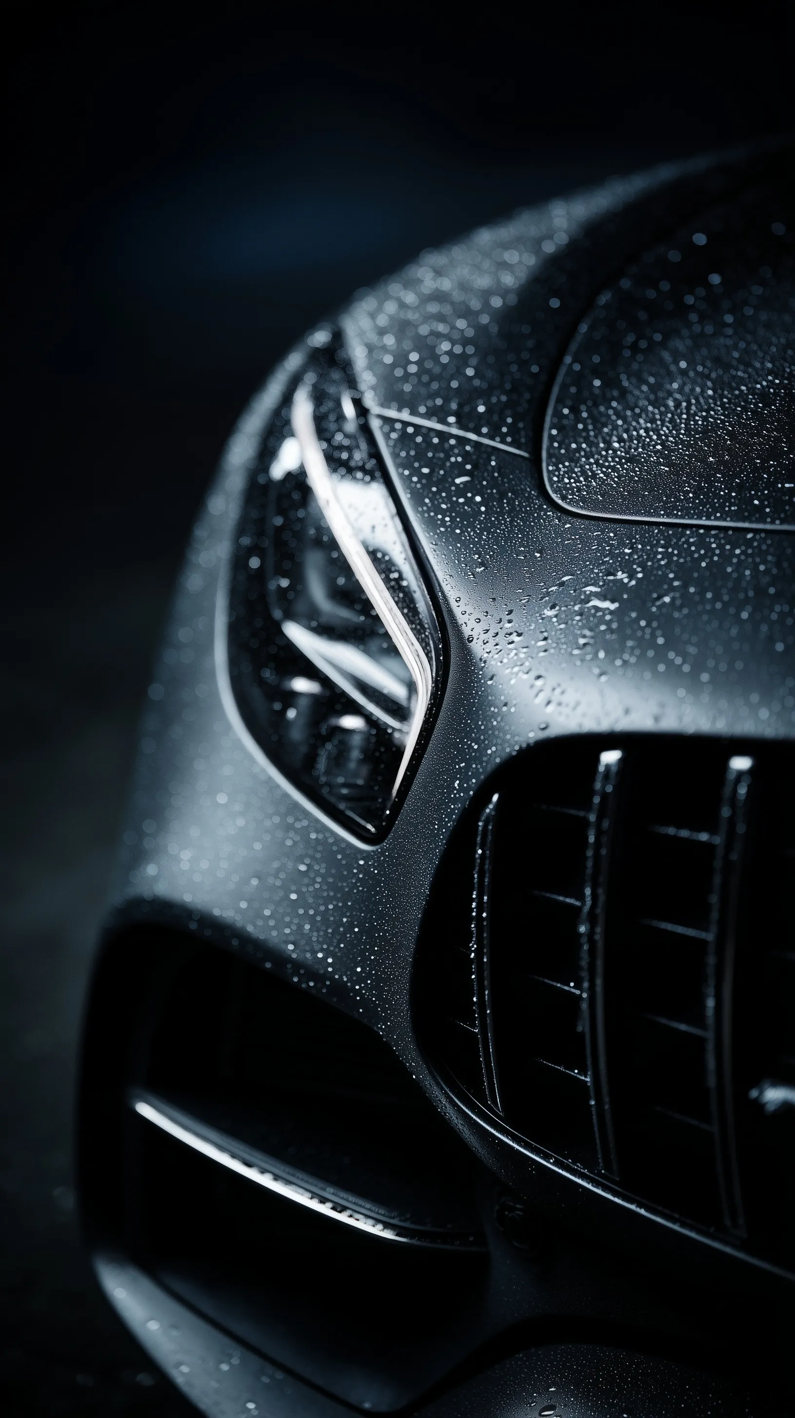 Extreme close-up of a wet Mercedes AMG GT Panamericana grille with moody dark metallic reflections.