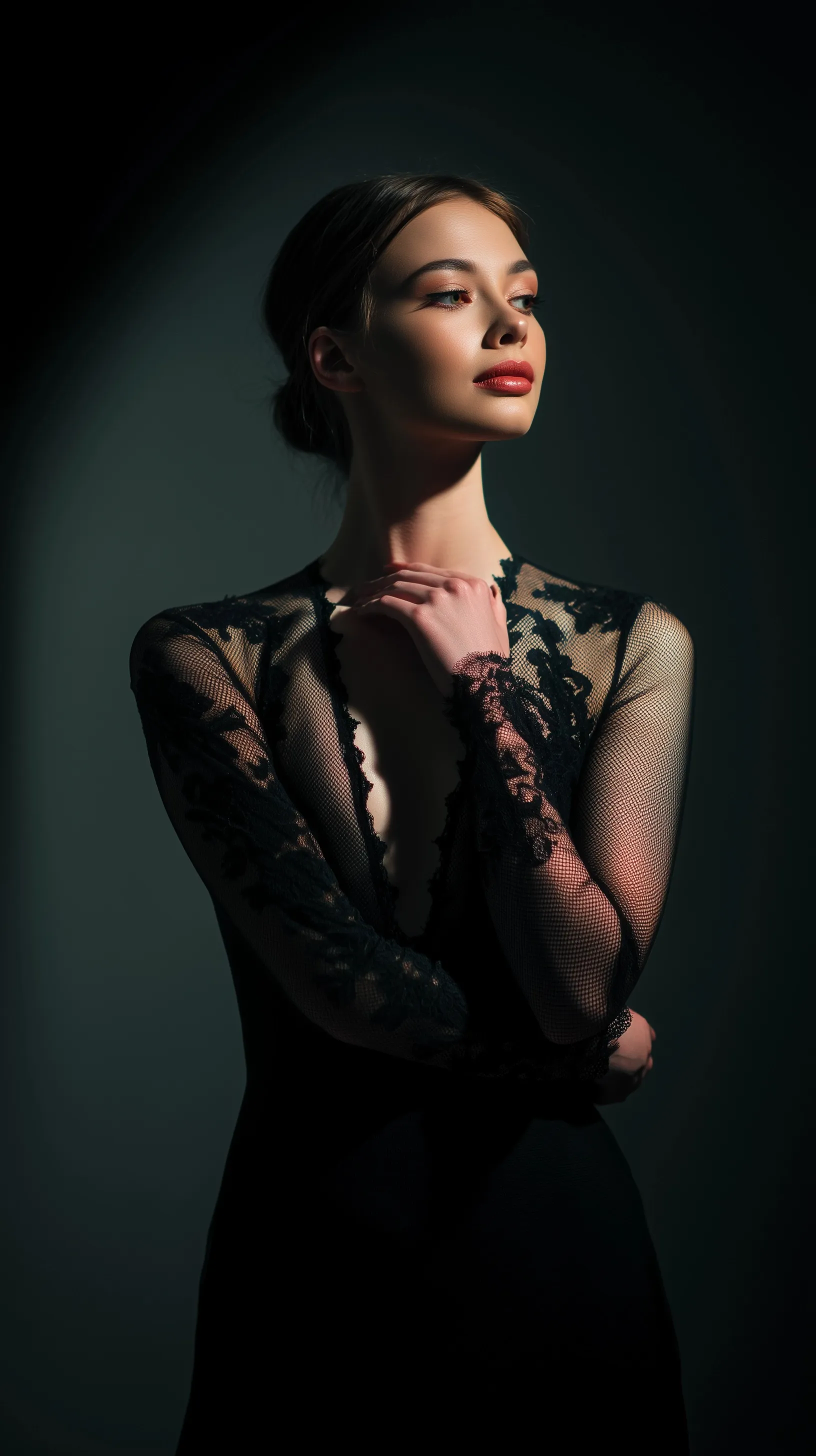 A beautiful woman in her 20s wearing a sheer black lace evening dress in cinematic chiaroscuro spotlight.