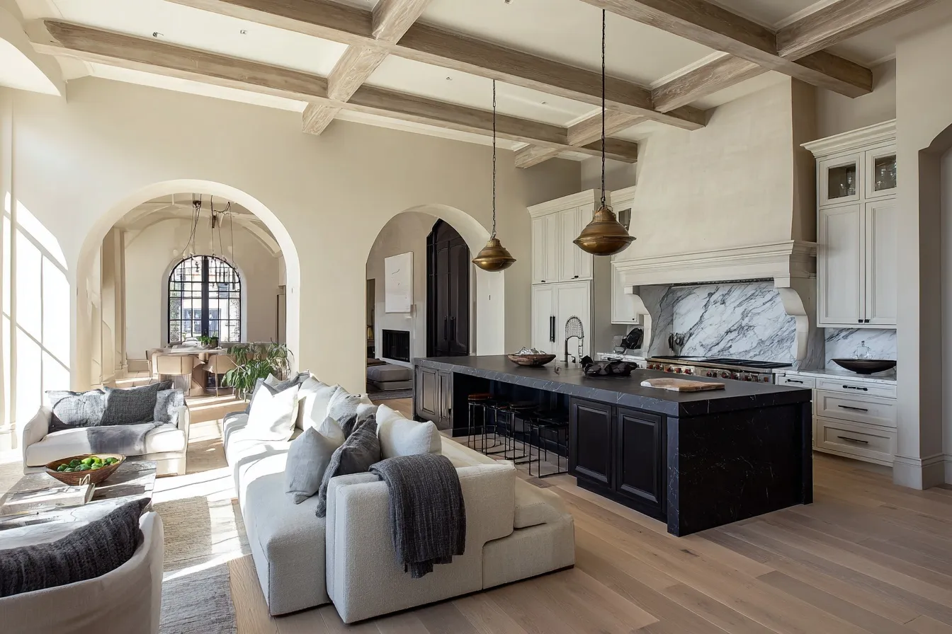 Luxury European open kitchen with marble range alcove, dark soapstone island, and coffered ceilings in a bright home.