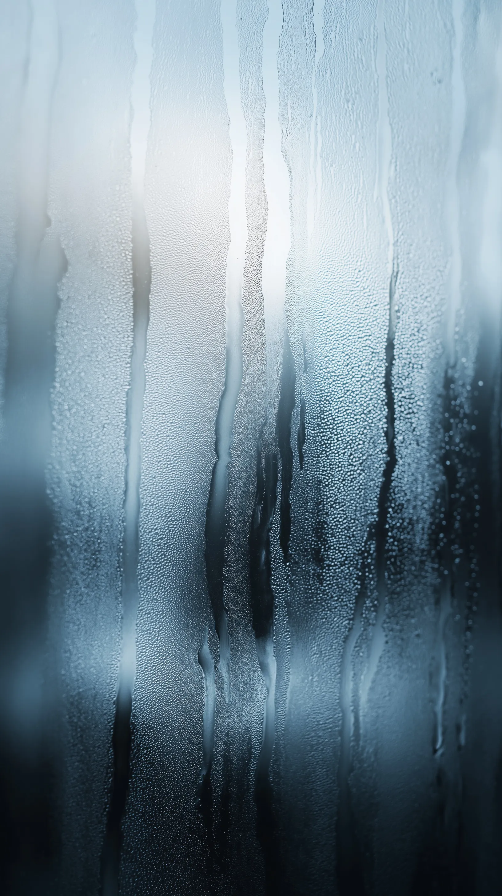 Close-up of rain droplets and condensation streaks on a foggy, cool-toned glass window, hyper-realistic style.