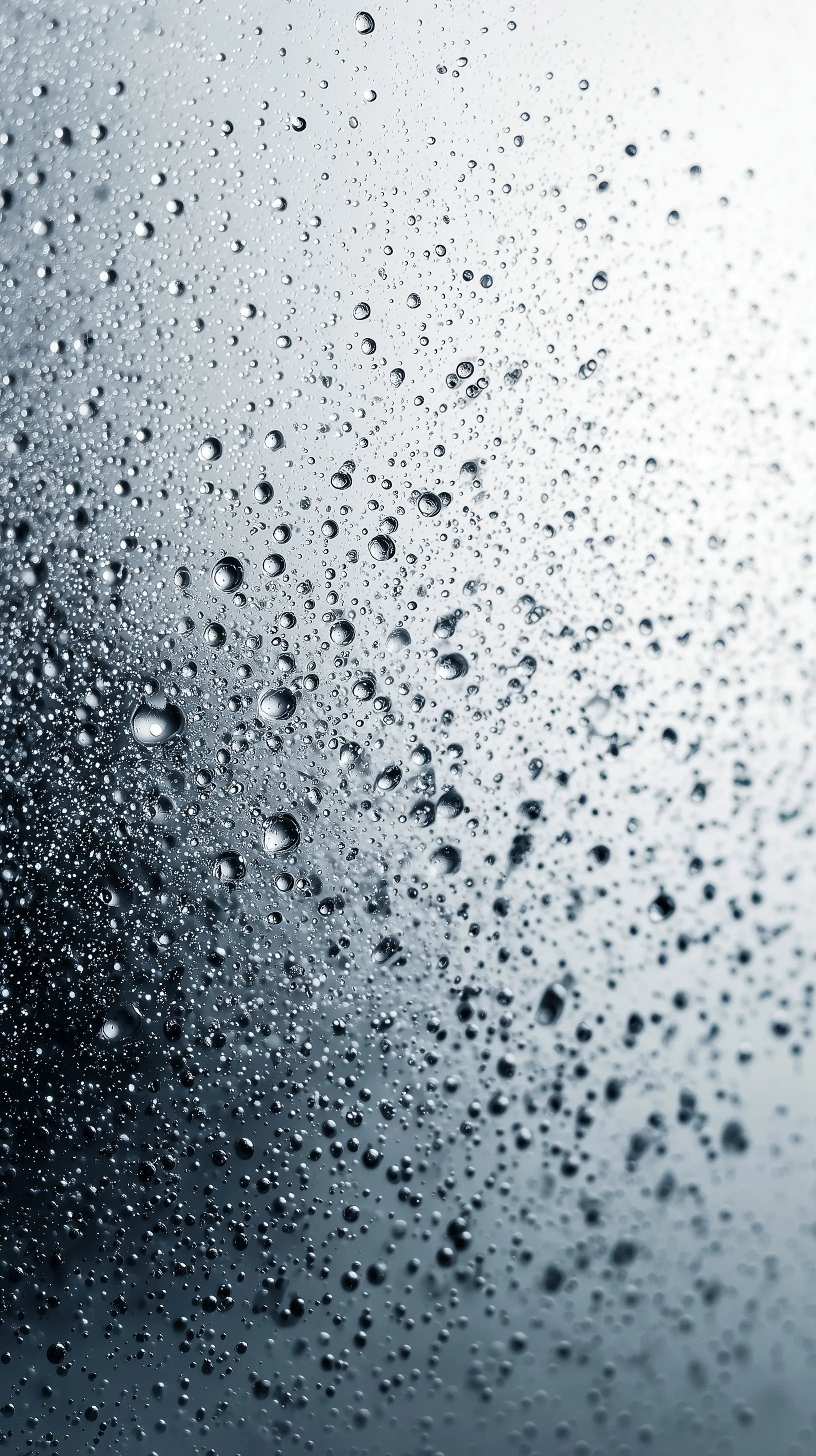 Close-up of fresh water droplets misted on clear glass against a clean white background.