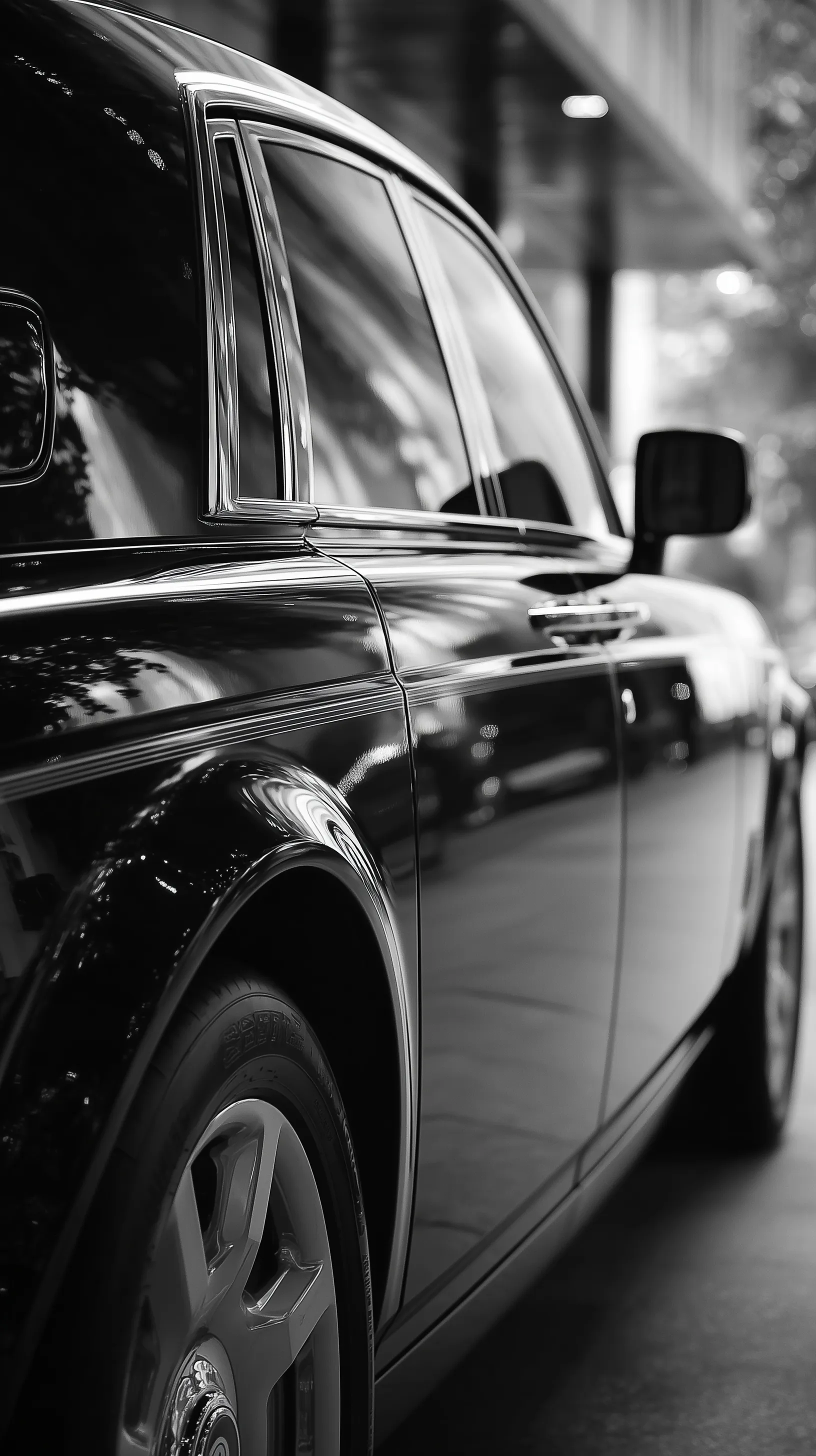 A sleek black and white Rolls-Royce Phantom door showing mirror-like city reflections and elegant film grain.