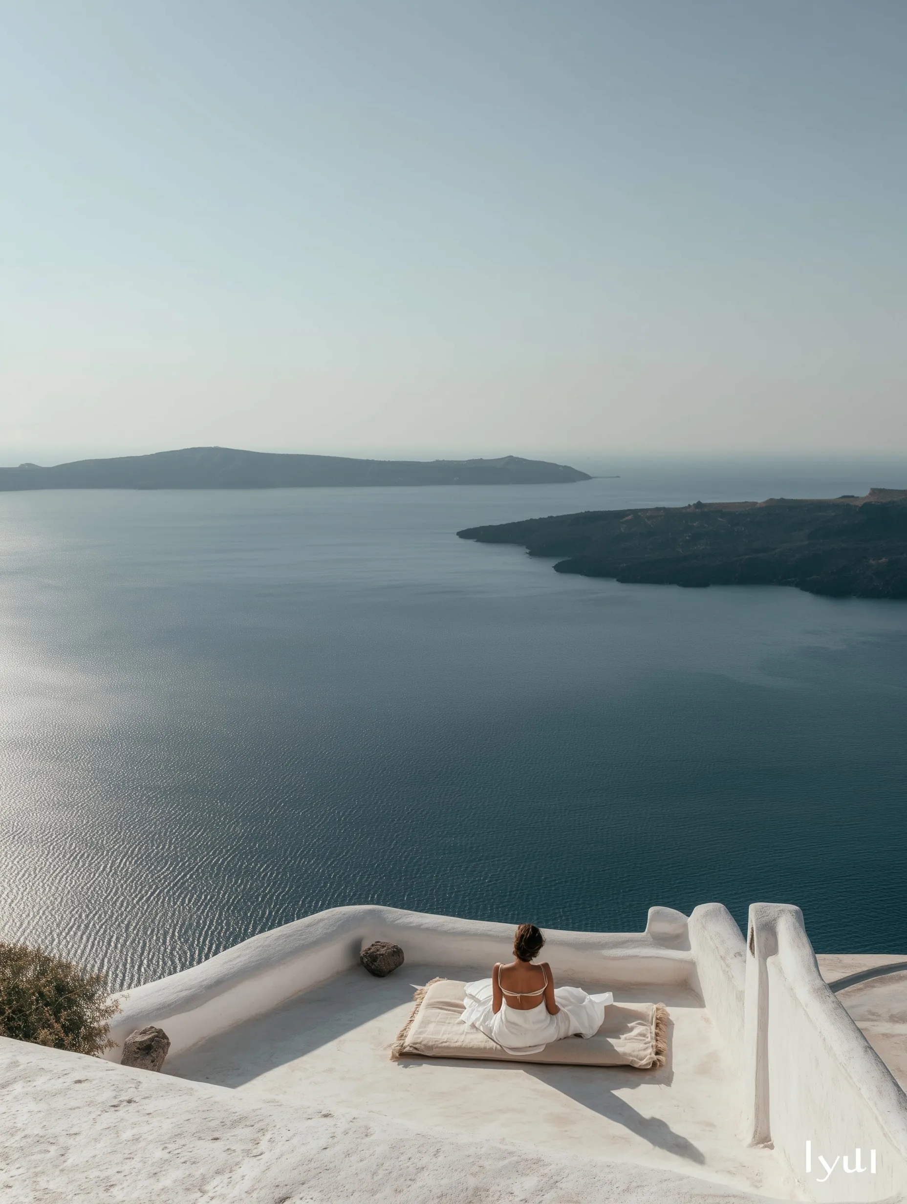 A woman relaxing in a summer outfit on a minimalist white Santorini rooftop overlooking the deep-blue Mediterranean.
