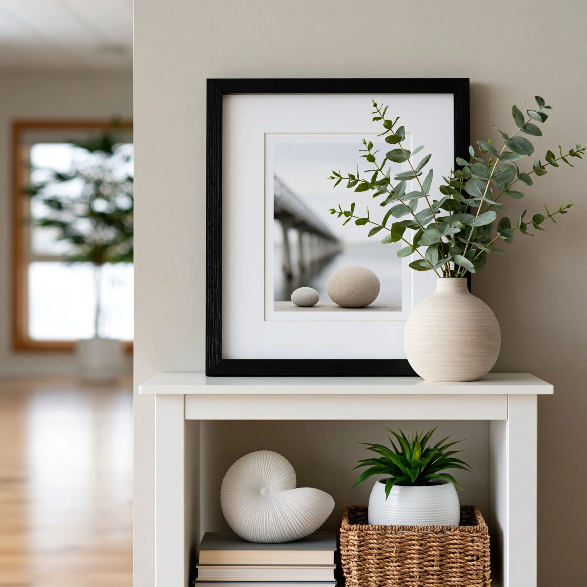 A sleek black wood framed art piece displayed on a minimalist console table in soft morning light.