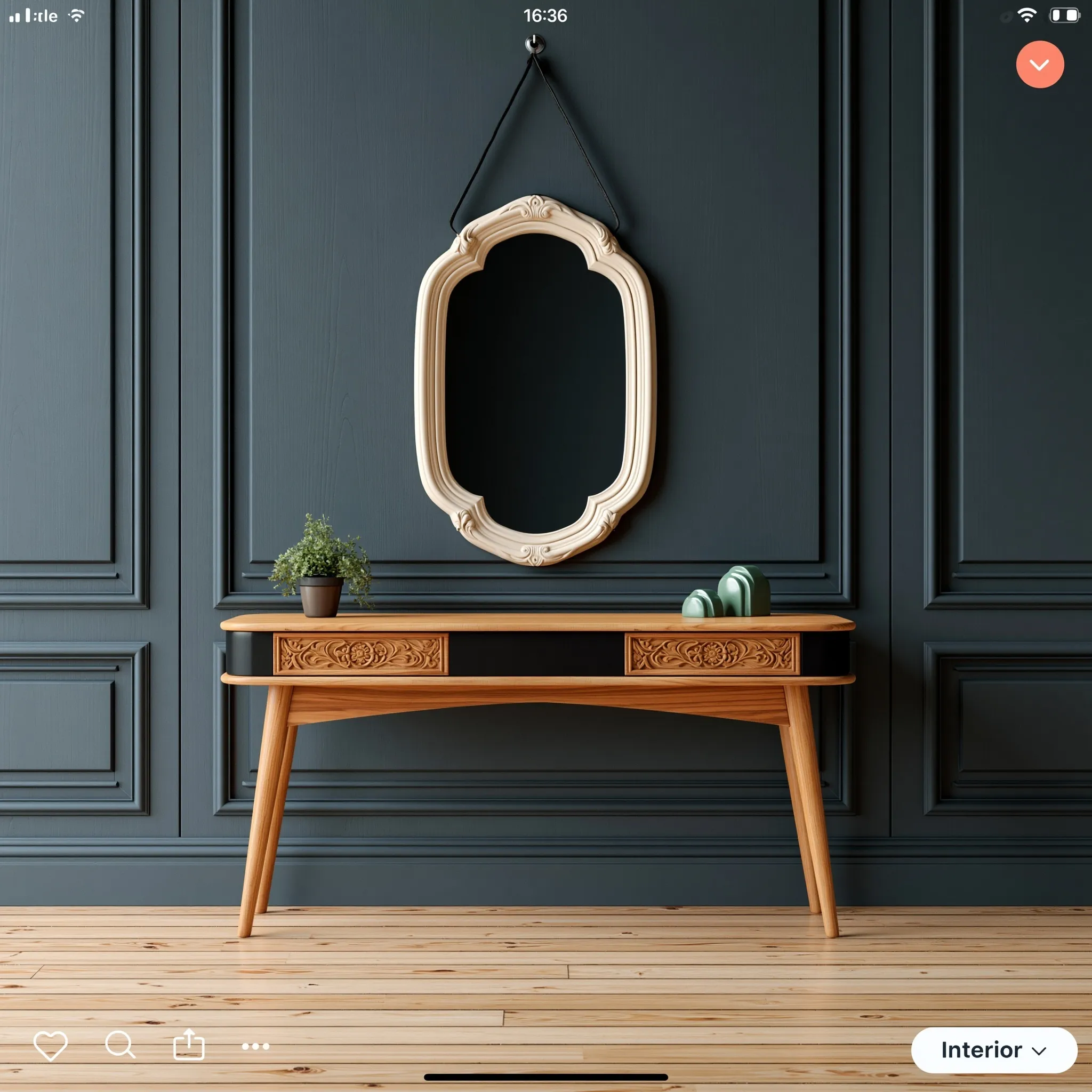 Elegant minimalist console table with carved wood drawers, ornate mirror, and decor against a dark wood wall.
