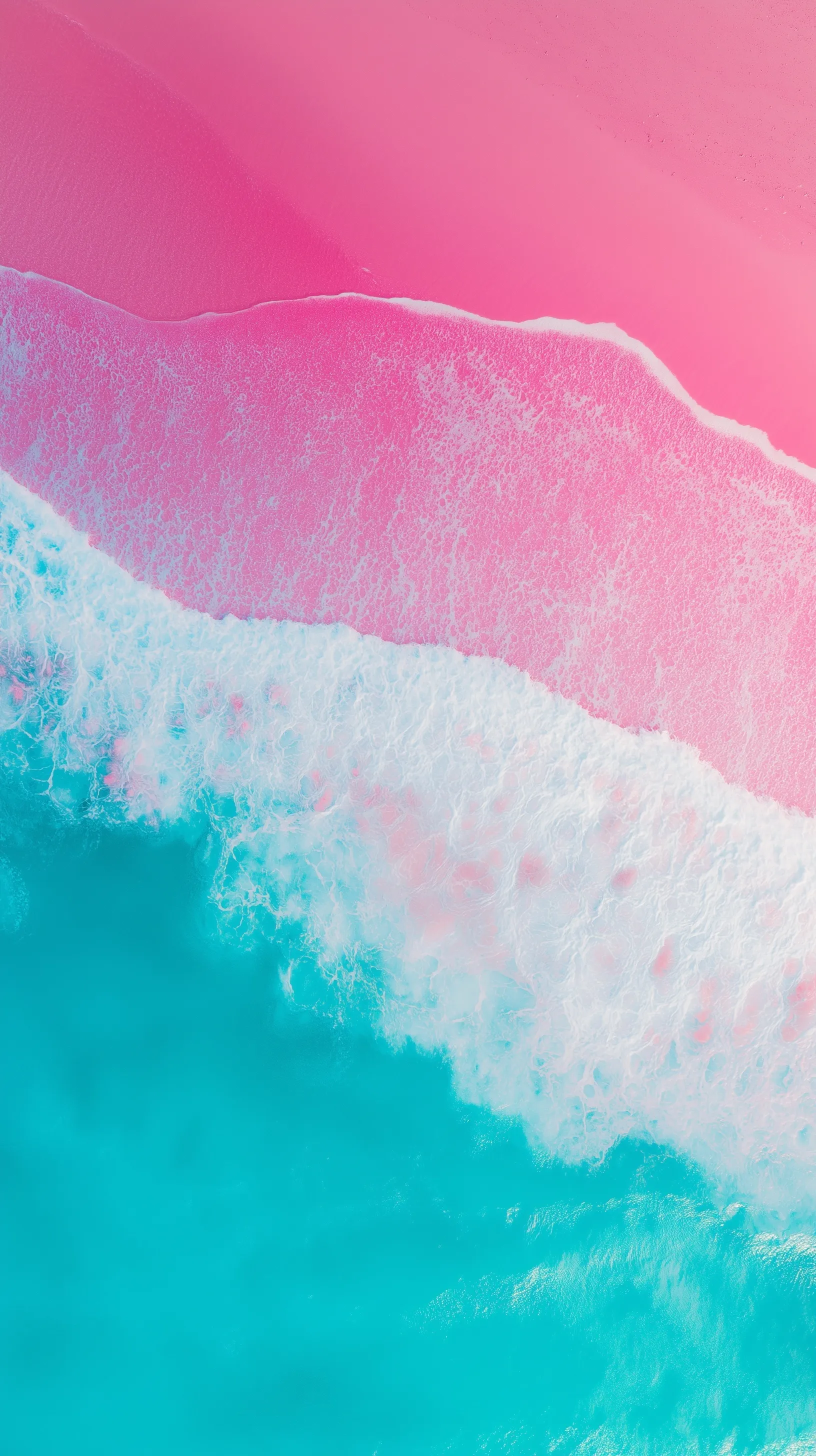 Aerial top-down view of a magical pink sand beach with turquoise ocean waves and white foam, vibrant vertical wallpaper.