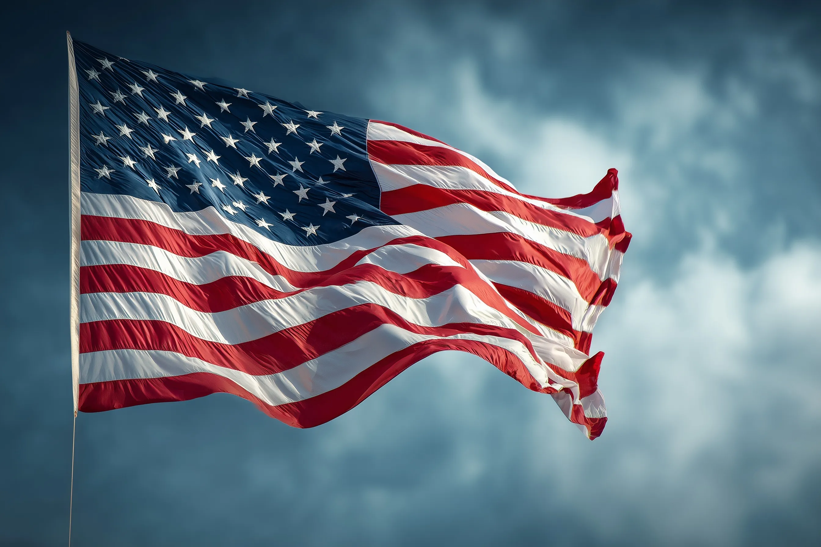 A vibrant American flag waving against a bright, clear blue sky background.
