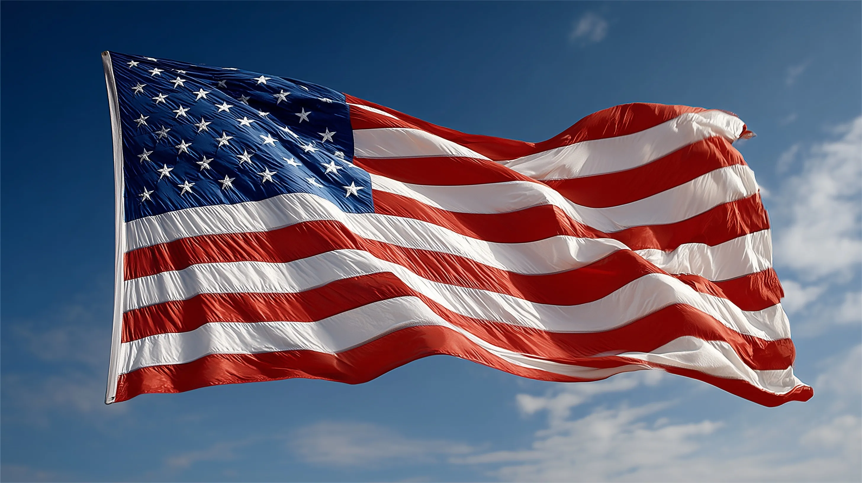 A vibrant American flag waving against a clear, bright blue sky.