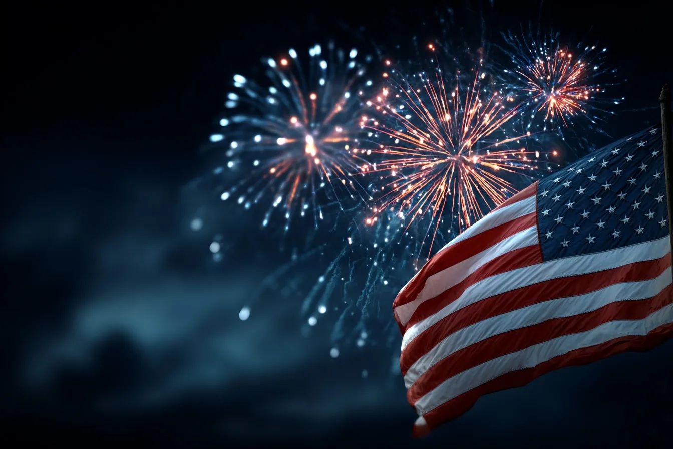American flag waving against a dark night sky with vibrant red and blue Independence Day fireworks exploding nearby.