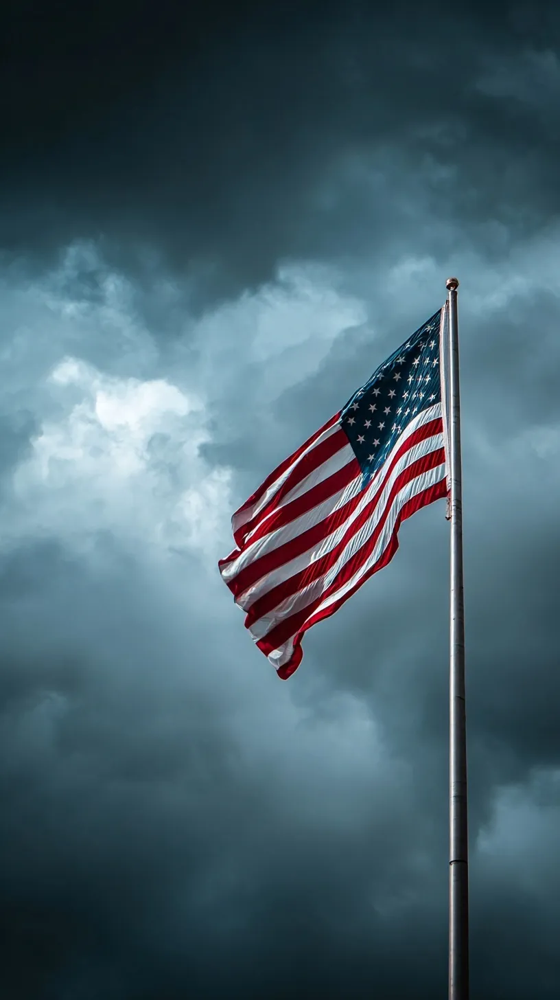 A detailed close-up of an American flag blowing in the wind against a dramatic cloudy sky.